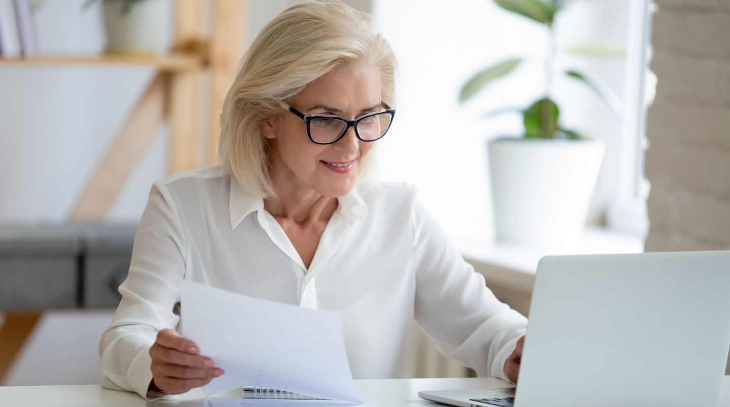Personne organisant un dossier de rectification avec formulaires officiels et correspondances administratives